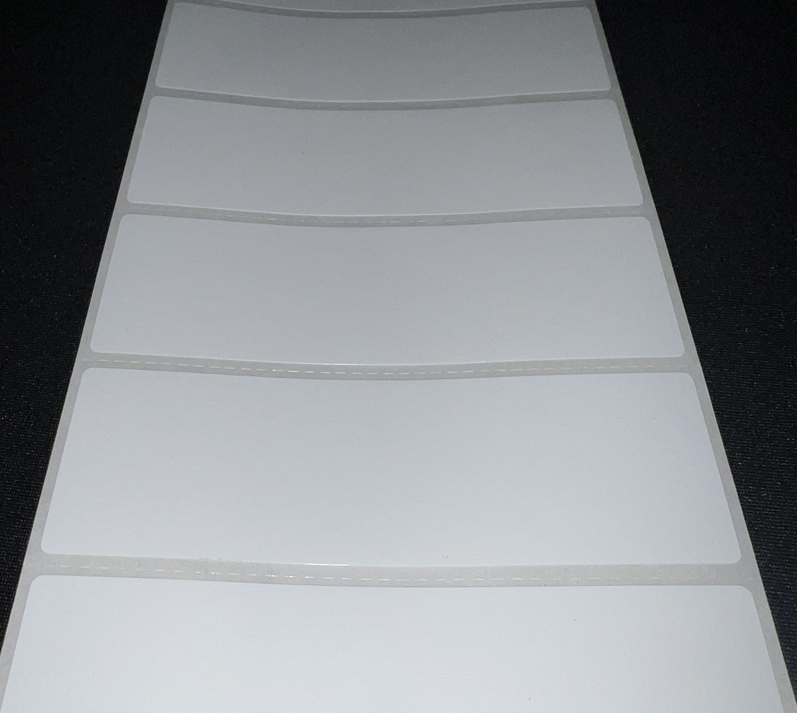 Sheet of perforated white labels with evenly spaced tear lines.